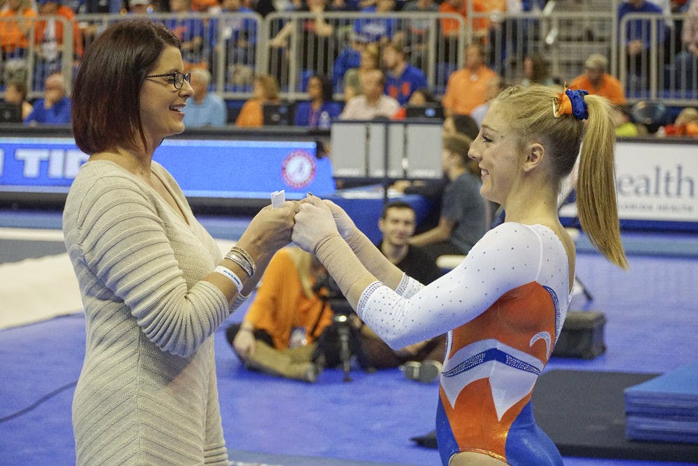 <p>UF coach Jenny Rowland fist-bumps with Alex McMurtry during Florida's win over Alabama on Jan. 29, 2016, in the O'Connell Center.</p>