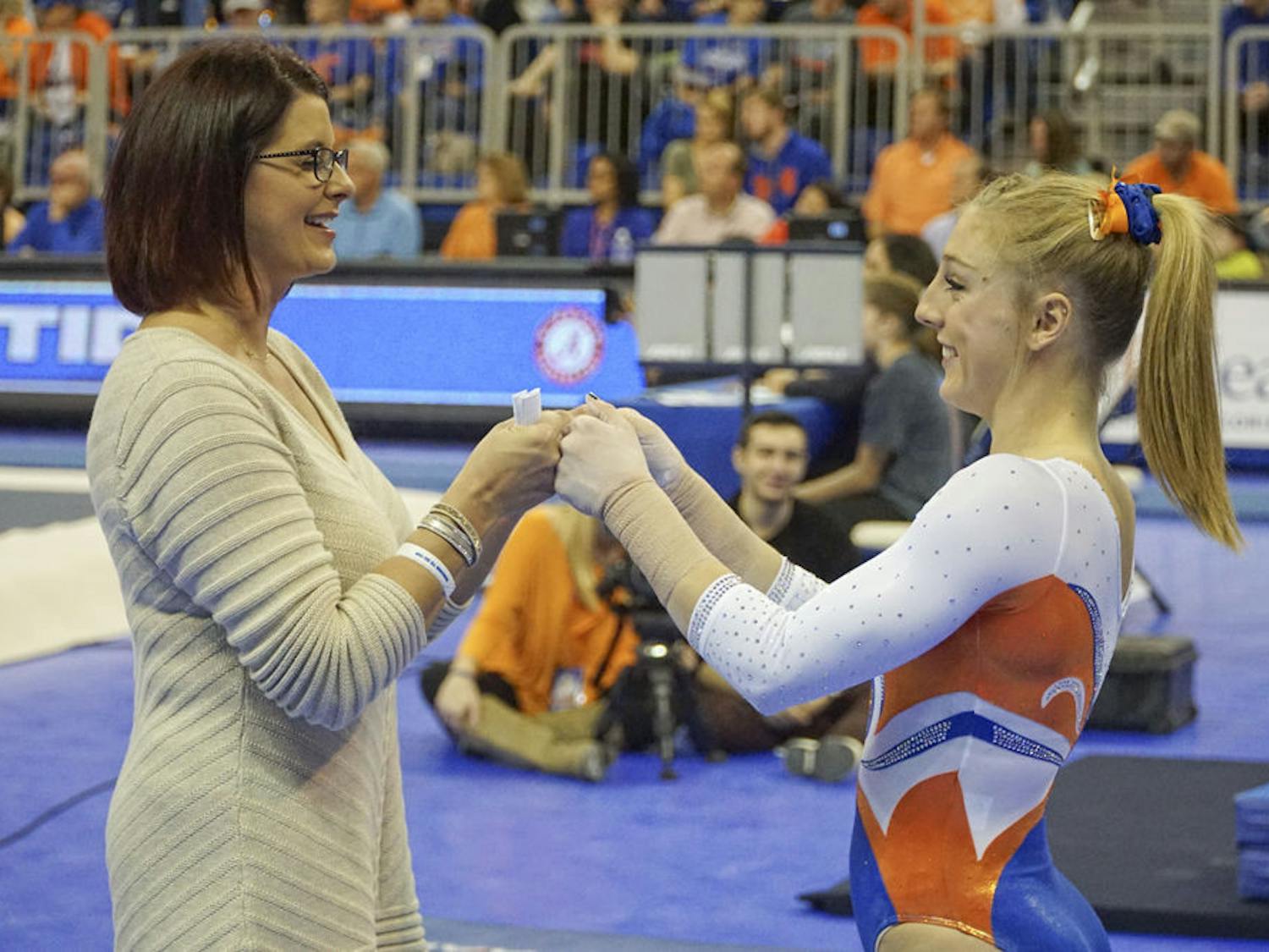 UF coach Jenny Rowland fist-bumps with Alex McMurtry during Florida's win over Alabama on Jan. 29, 2016, in the O'Connell Center.