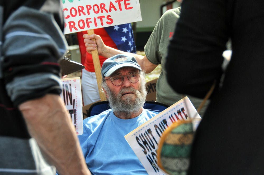 Protesters gathered outside U.S. Rep. Ted Yoho's Gainesville office to demand a town hall meeting when he recesses. 