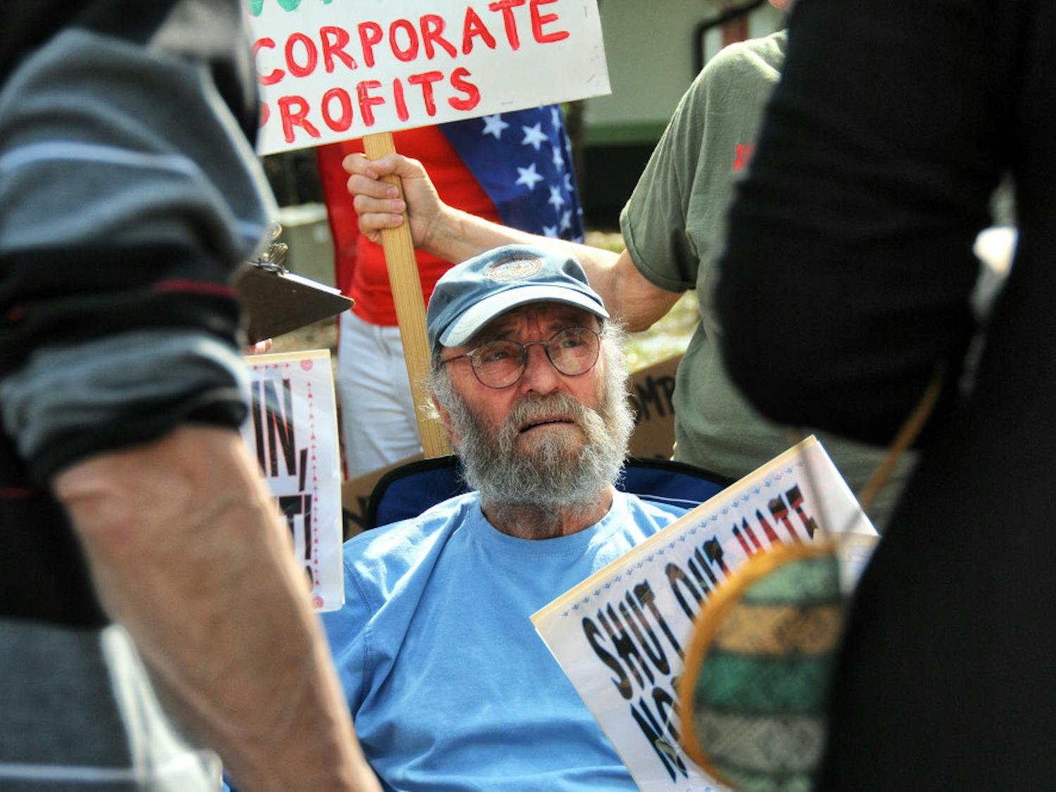Protesters gathered outside U.S. Rep. Ted Yoho's Gainesville office to demand a town hall meeting when he recesses.