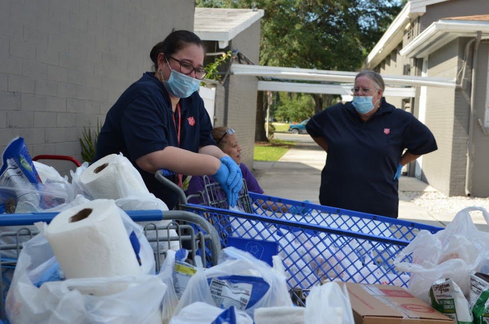 Left to right:&nbsp;Priscilla Gonzalez,&nbsp;Mayda Rios and&nbsp;Jean Graham wait for cars to arrive before distributubg supplies at the Salvation Army.&nbsp;