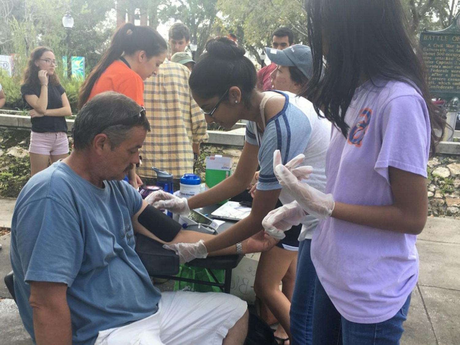 Rianna Haniff, a 20-year-old UF biochemistry and molecular biology junior, conducts her first blood pressure screening on Steve Mclain, a Gainesville resident. The screenings have taken place every Sunday since September and are a part of the new UF chapter of the organization Hearts for the Homeless.