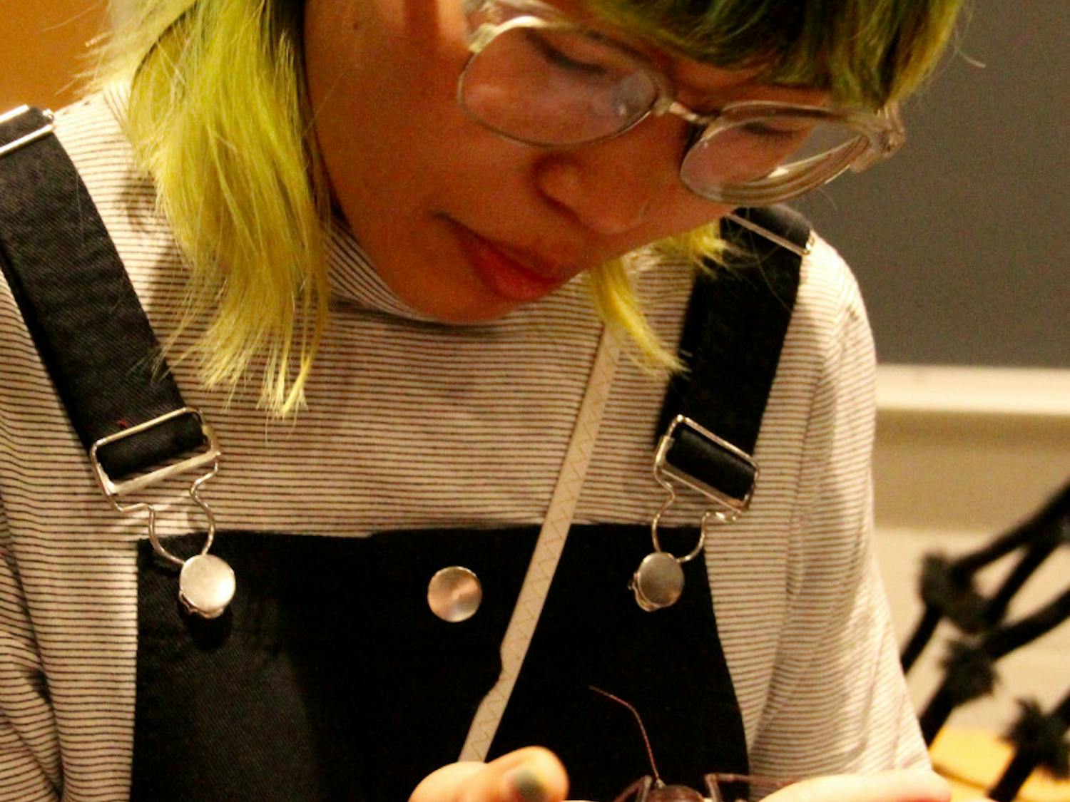 Emily Tran, a 20-year-old UF graphic design junior, holds a vinegaroon. The arachnid expels acetic acid when it feels threatened, which smells like vinegar.