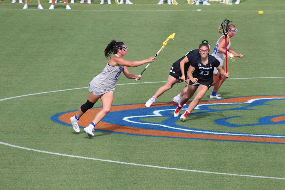 2021 AAC Midfielder of the Year Shannon Kavanagh, pictured in grey, passes down the field against Cincinnati in the conference semifinal on May 6. Kavanagh scored her 200th goal during the game.