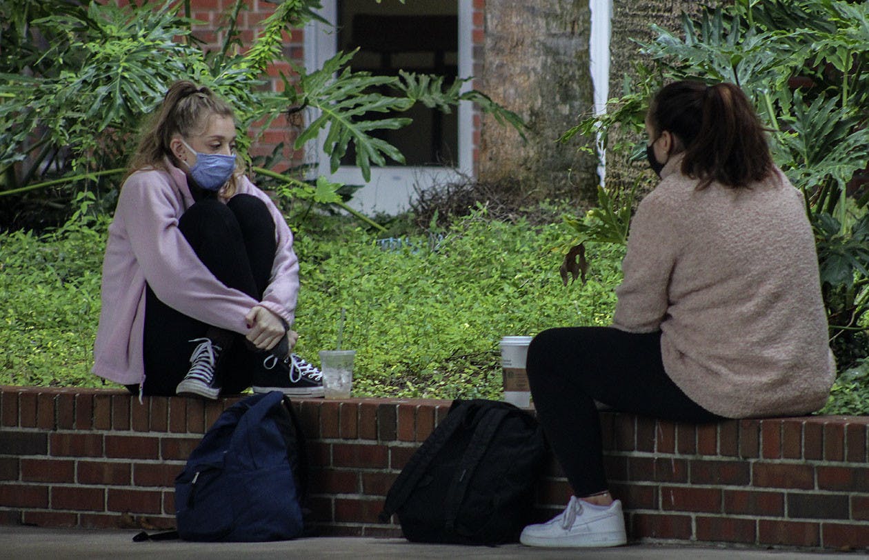Juliet Rapaport, UF health science junior (left) and Hannah Shiffner, UF history junior (right), grab some Starbucks drinks together outside of Library West on Wednesday, Jan. 13, 2021. The pair said they went to high school together and met to catch up.