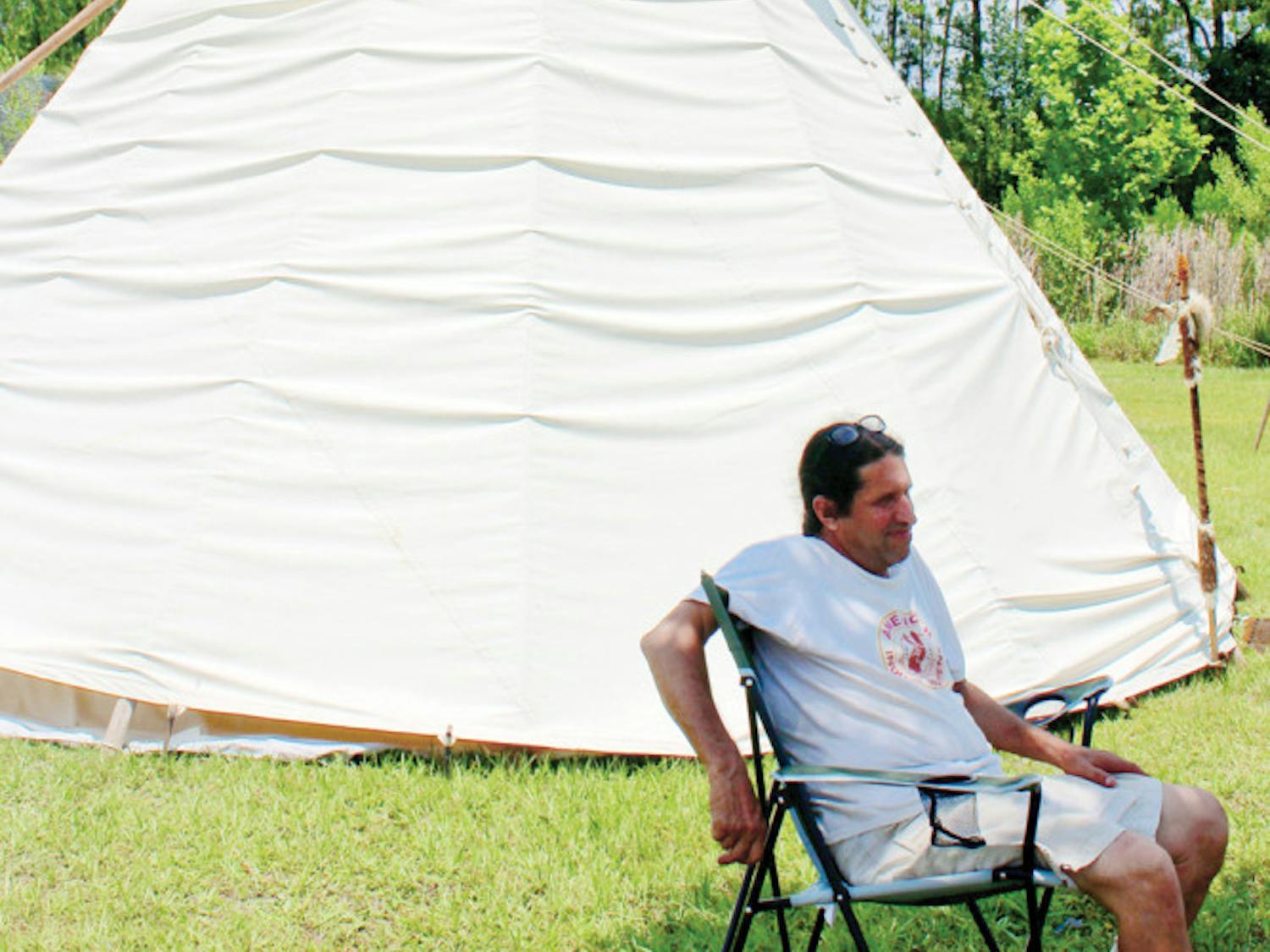 Running Bear, owner of Running Bear’s Trading Post, sits outside of his tipi village at the Waldo Farmers and Flea Market Sunday. The tipis are decorated with traditional Native American items.