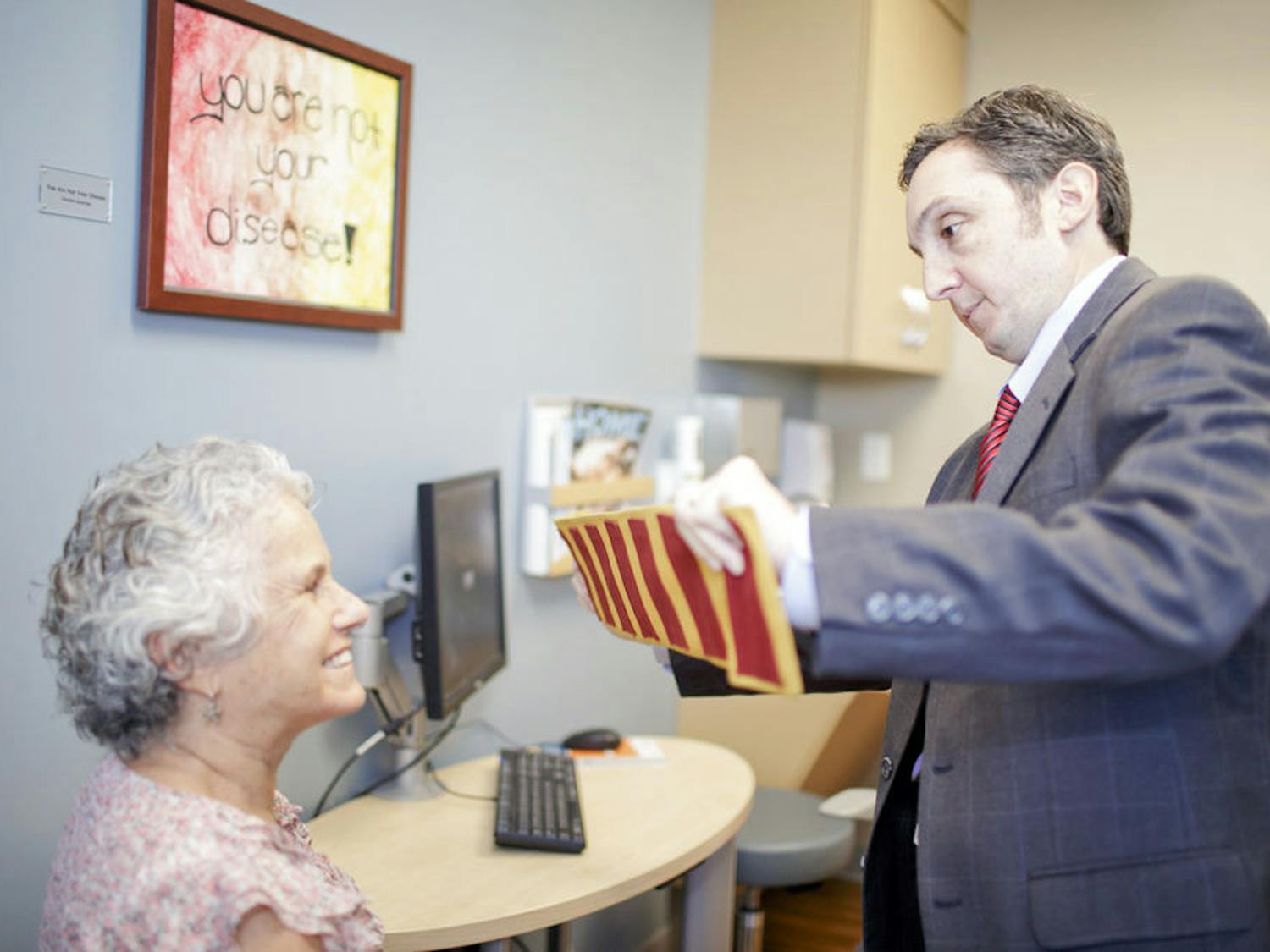 Dr. Michael Okun (right), a doctor at the UF Center for Movement Disorders and Neurorestoration, interacts with a patient. Okun was a member of a Champions for Change panel at the White House last Monday addressing Parkinson’s treatments and research.