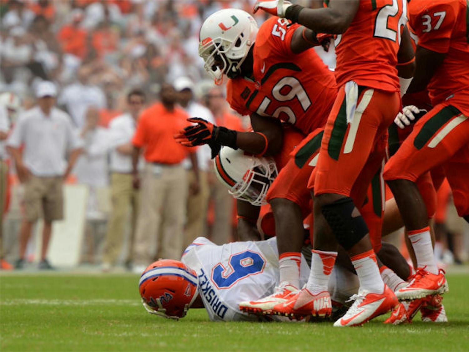 Jeff Driskel lies on the ground after being sacked by a group of Miami defenders during the Gators’ 21-16 loss to the Hurricanes on Saturday in Sun Life Stadium. Driskel had three turnovers in the game.