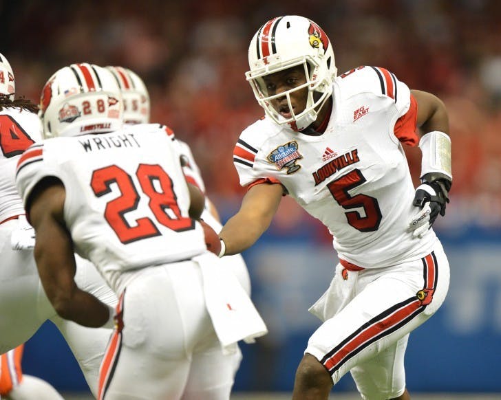 Louisville quarterback Teddy Bridgewater hands the ball off to running back Jeremy Wright during the Allstate Sugar Bowl in New Orleans, La.&nbsp;