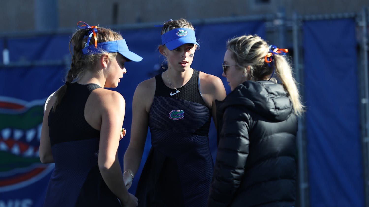 UF assistant coach Lauren Embree talks to Bente Spee and Alicia Dudeney during the Gators&#x27; match against the Ospreys on Sunday, January 23, 2022 at Linder Stadium at Ring Tennis Complex in Gainesville, FL / UAA Communications photo by Anna Carrington