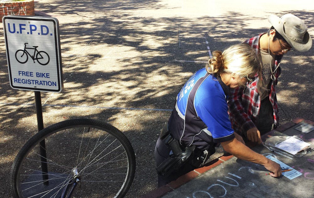 Boming Zhang, a 21-year-old UF accounting junior, registers his bicycle with a UPD investigator on Turlington Plaza on Monday. UPD offers the free service to counter bicycle theft.