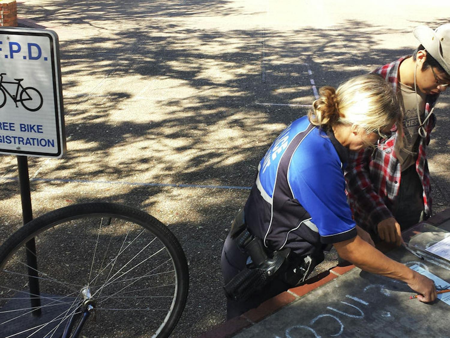 Boming Zhang, a 21-year-old UF accounting junior, registers his bicycle with a UPD investigator on Turlington Plaza on Monday. UPD offers the free service to counter bicycle theft.