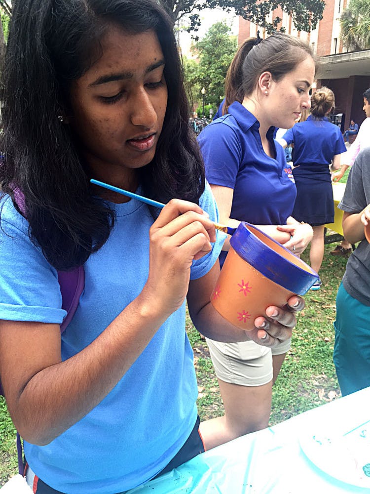 Anisha Patel, a 19-year-old UF finance freshman, paints a flower pot during Student Government’s Freshman Leadership Council’s Spring Forward, Look Back event on the Plaza of the Americas on Tuesday.