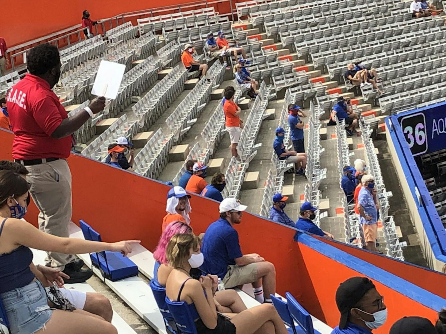 A S.A.F.E. staff member instructs fans in the student section to put on their masks at Saturday’s home opener in Ben Hill Griffin Stadium.