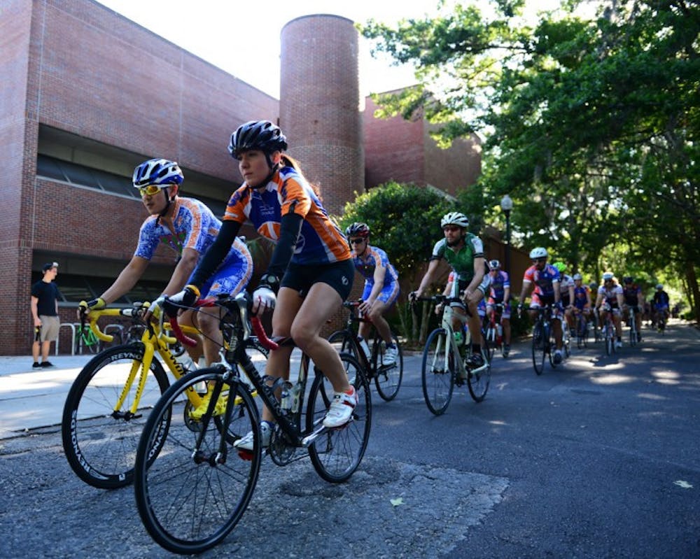 <p>Karen Edmonds leads a pack of cyclists past the Fine Arts building Monday afternoon. The Florida Cycling club organized the 12-mile ride to honor Edmonds’ late brother, Michael Edmonds.</p>