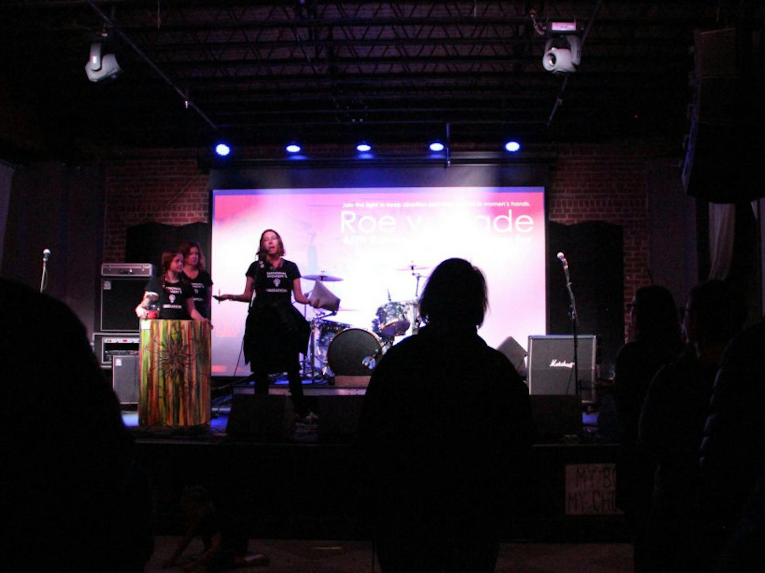 Amy Coenen and her daughter Ella share the stage with another member of the National Women's Liberation organization right before announcing the first winners to the raffle inside The Wooly on Saturday night. The anniversary show was put together to celebrate the 45th anniversary of the Roe v. Wade decision.