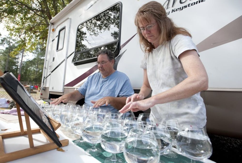 <p>Eric and Susan Scites practice the glass harp Wednesday afternoon in preparation for the opening of the Hoggetowne Medieval Faire. Eric, 49, and his wife, Susan, 47, travel the country demonstrating the instrument.</p>
