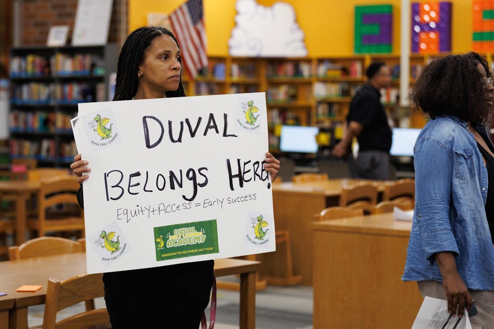 Tiara Murdock holds a sign in support of Duval Early Learning Academy at a community rezoning meeting held at Eastside High School in Gainesville, Fla., Wednesday, Feb. 11, 2026.  Duval Early Learning Academy is considered for closure under the proposed rezoning maps.
