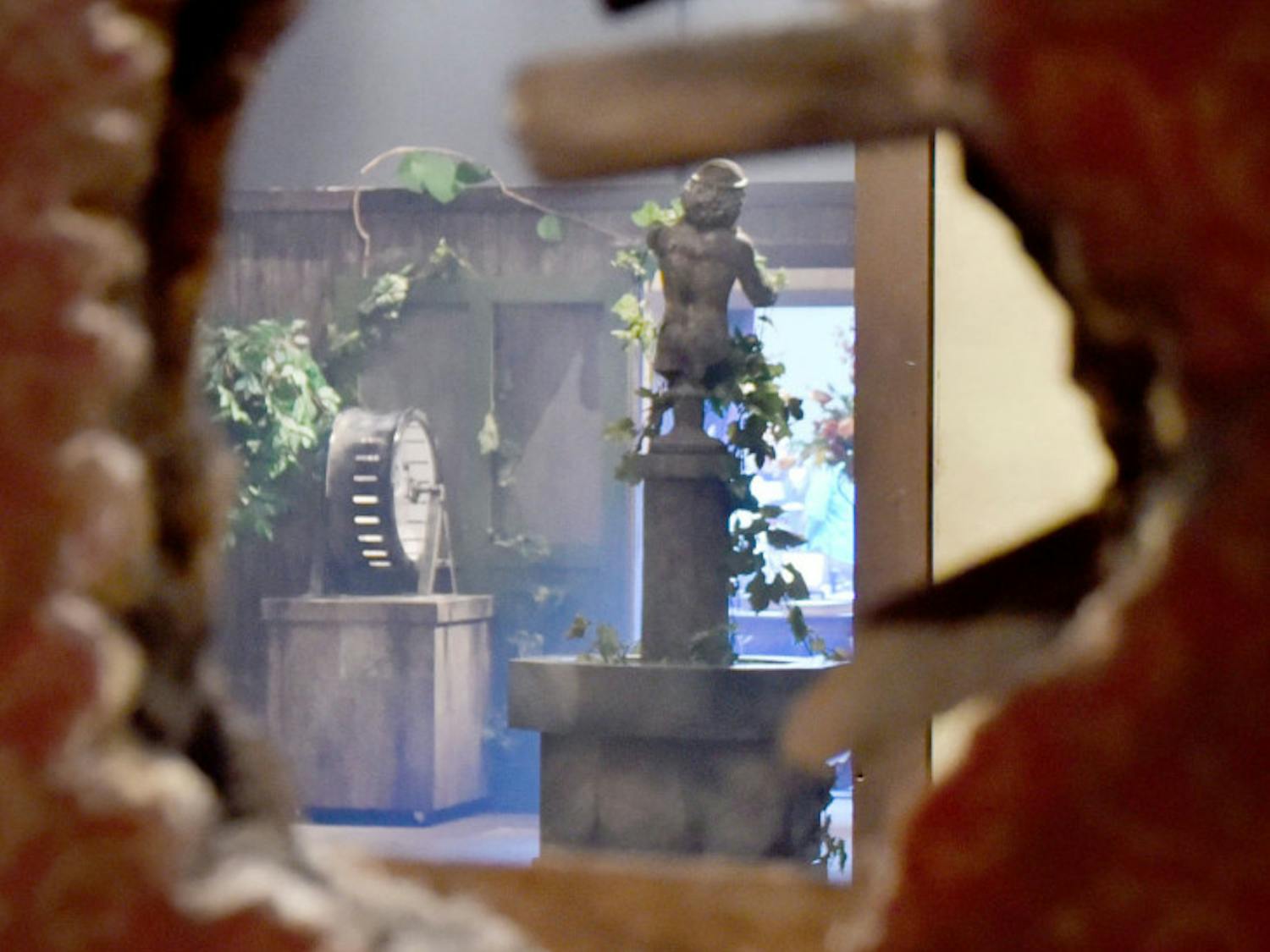 Seen through a hole in the Victorian house’s dining room wall at the Florida Museum of Natural History is the garden exhibit, hosting various poisonous plants.