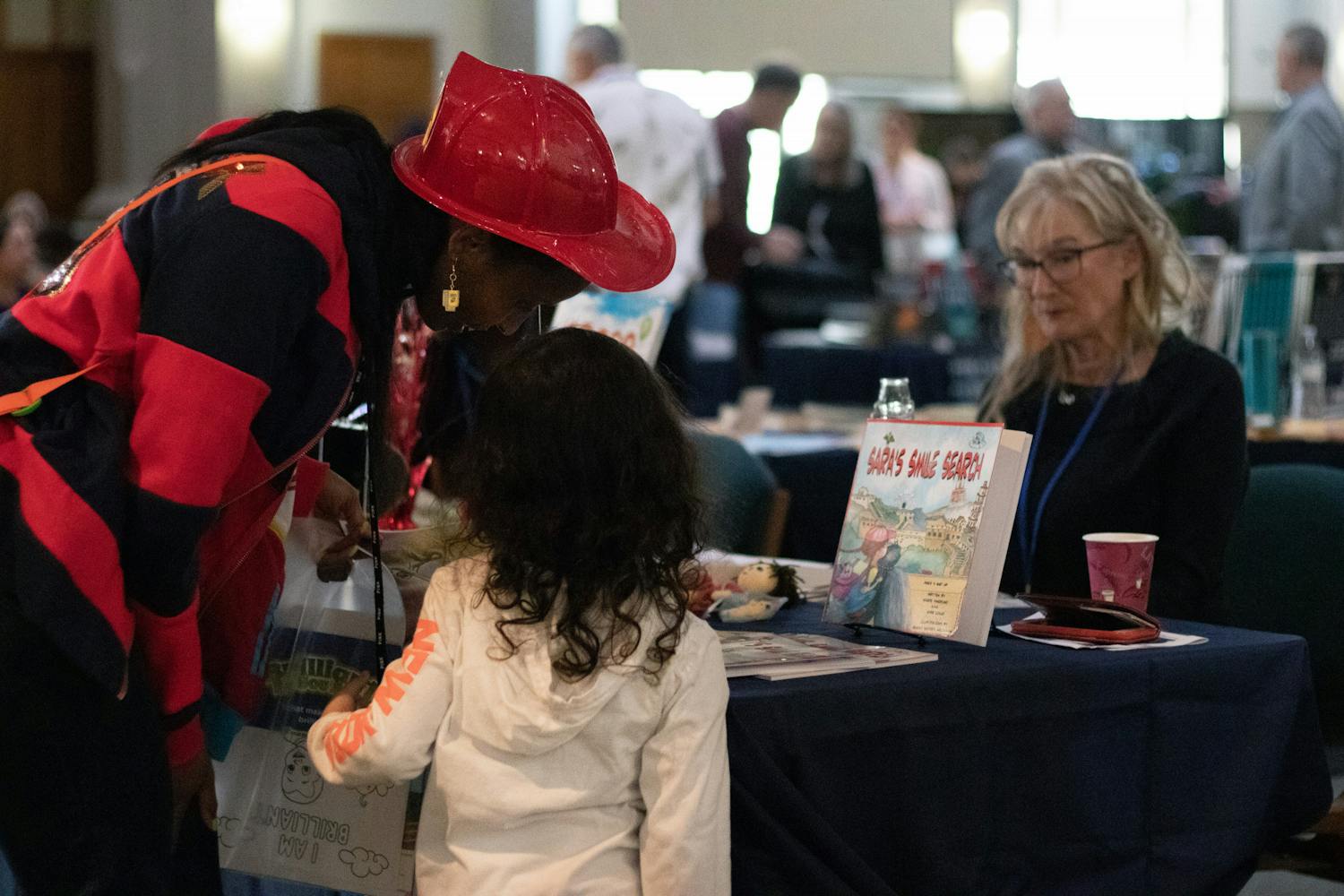Festival-goers stop by Jill Clark’s booth to read from the children&#x27;s poetry books she wrote Saturday, Jan. 28, 2023.