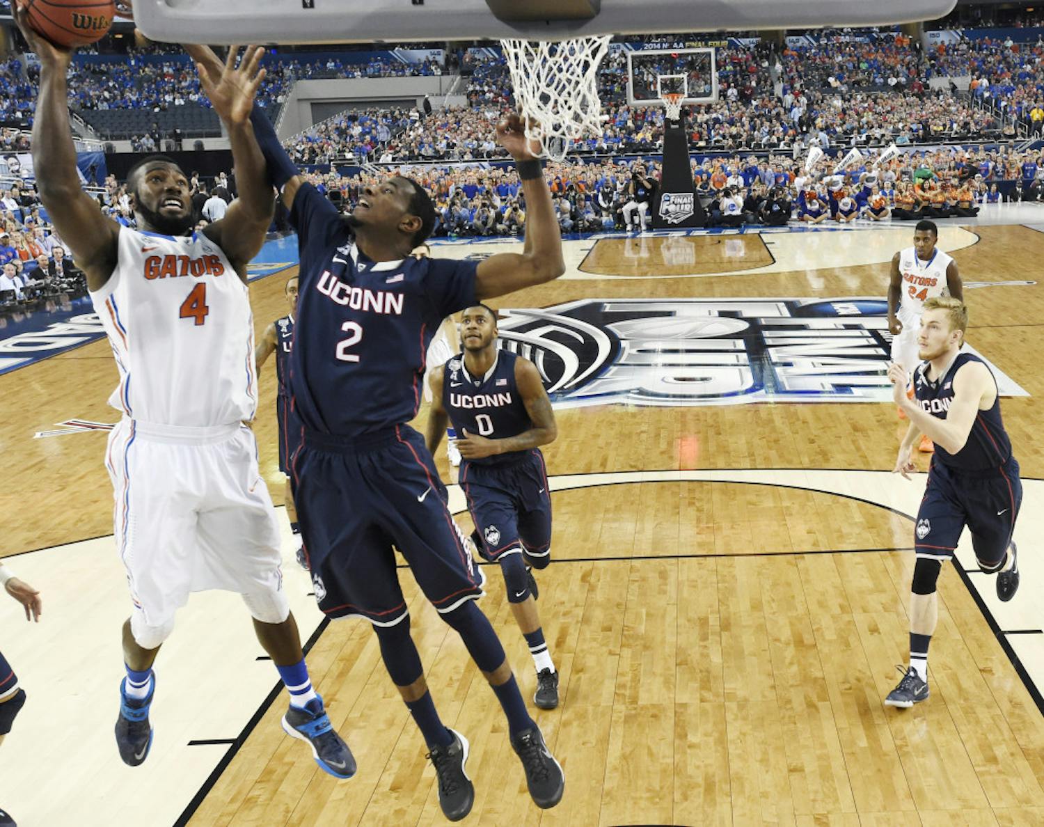 Florida center Patric Young (4) drives to the basket past Connecticut forward DeAndre Daniels (2) during the first half of the NCAA Final Four tournament game on Saturday in AT&amp;T Stadium in Arlington, Texas.