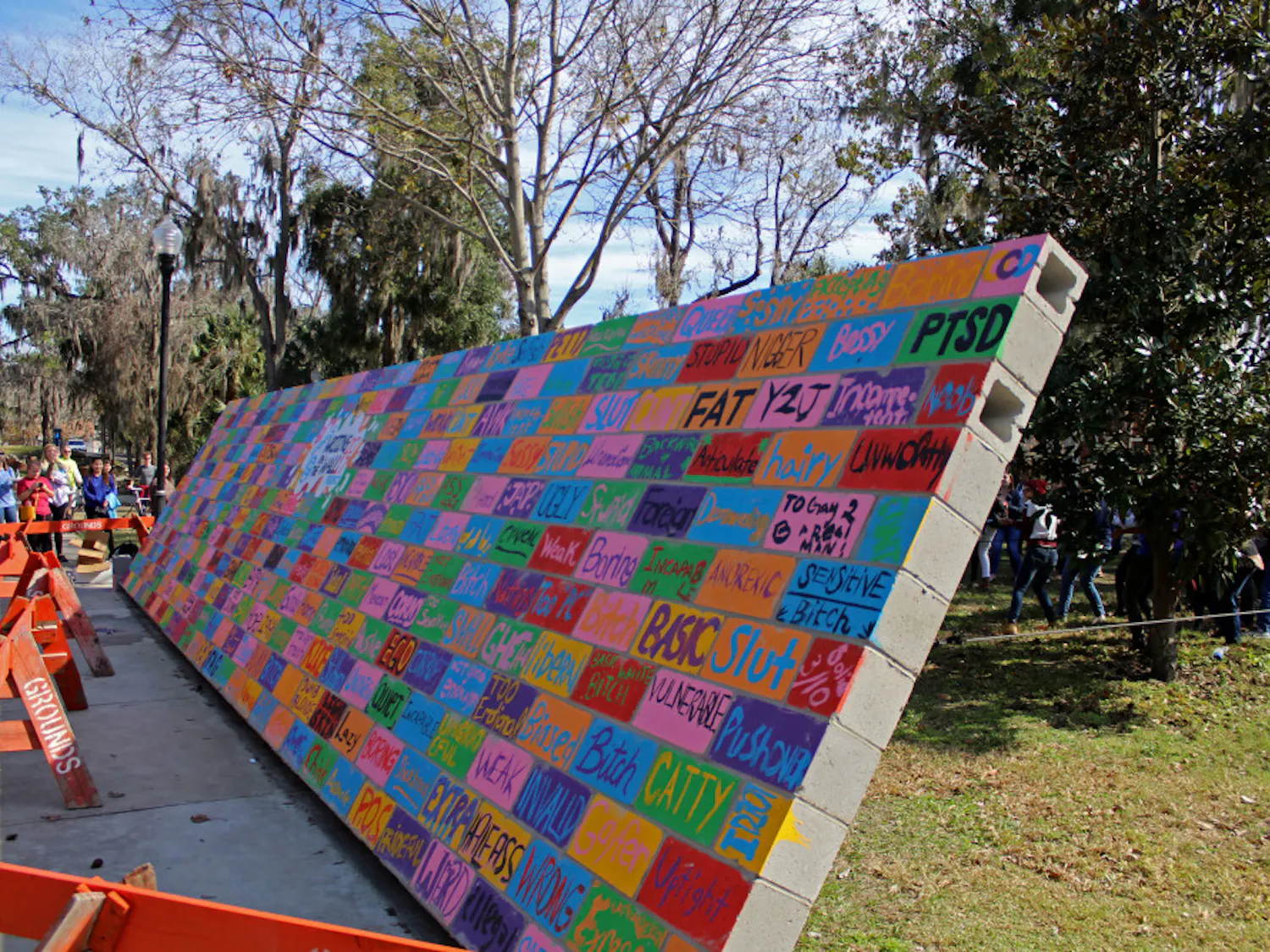 The wall is falling after being pulled down by dozens of volunteers at UF’s Inter-Residence Hall Association Social Justice's Writing on the Wall Program on Friday. The wall, which had been painted over with insults people had been told, was torn down and demolished as a means of catharsis.