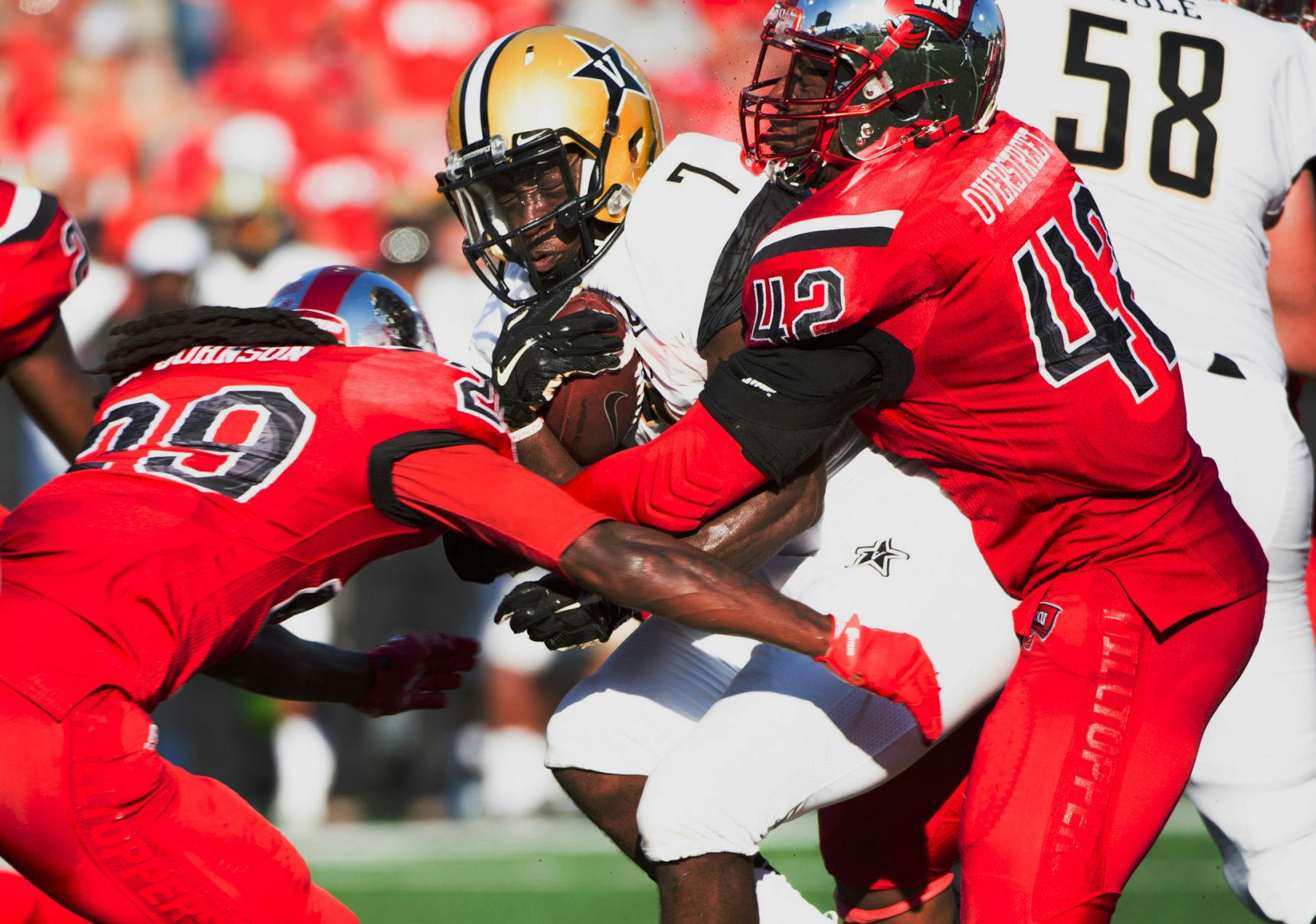 Vanderbilt University running back Ralph Webb (7) is tackled by multiple Western Kentucky University players in an NCAA college football game, Saturday, Sept. 24, 2016, in Bowling Green, Ky. (AP Photo/Michael Noble Jr.)