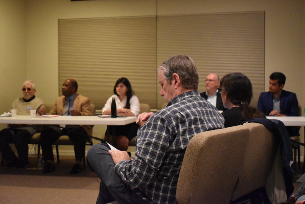 An attendee at the forum listens to City Commission candidates speak.