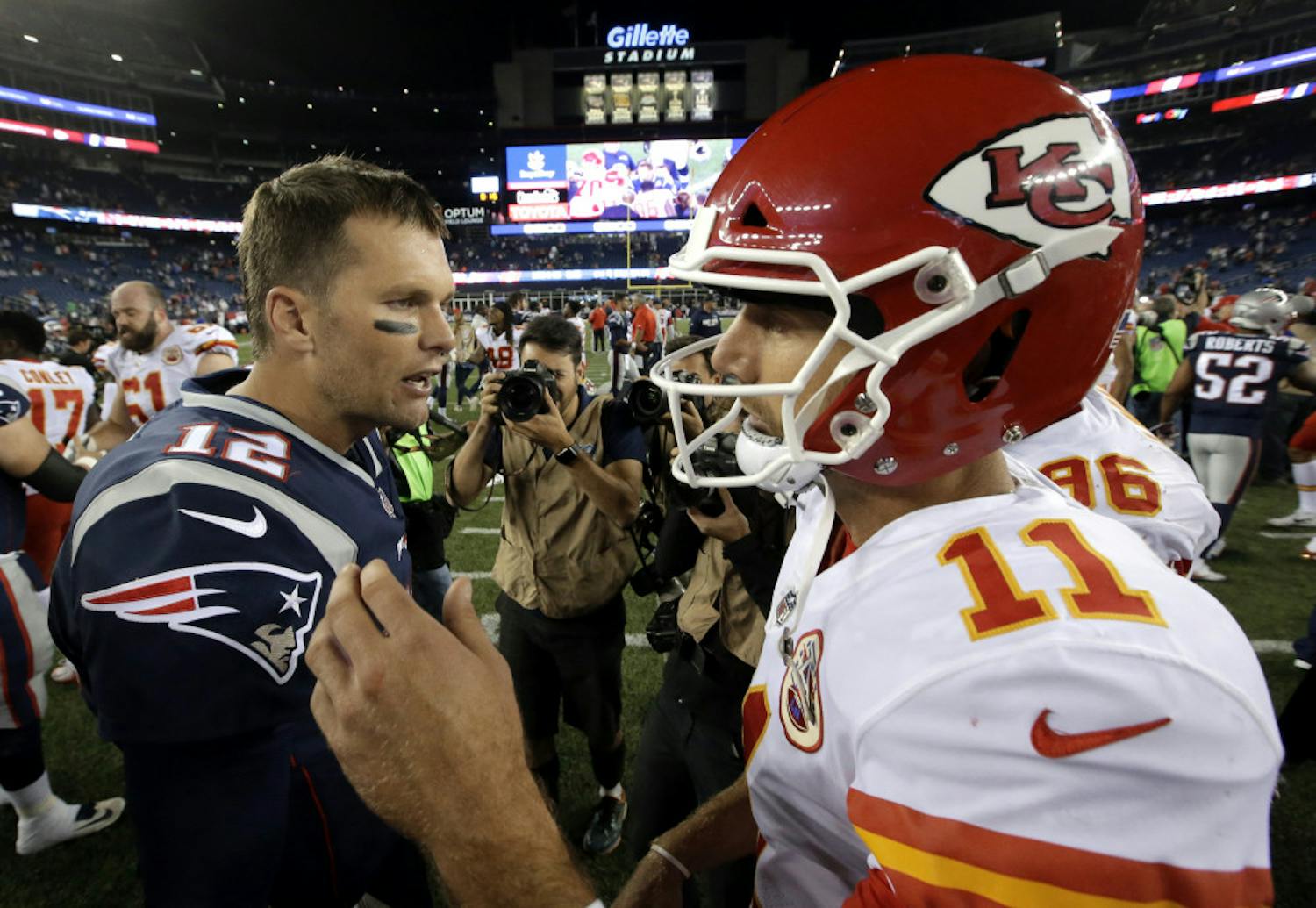 New England Patriots quarterback Tom Brady, left, and Kansas City Chiefs quarterback Alex Smith, right, speak at midfield after an NFL football game, early Friday, Sept. 8, 2017, in Foxborough, Mass. (AP Photo/Steven Senne)
