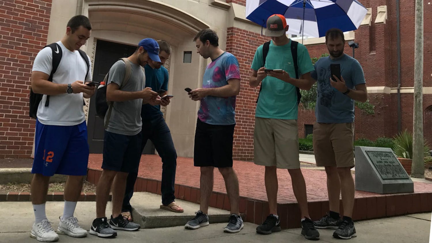 AJ Ariondo, 22, second from left; Nick Zeak, 23, third from right; and Rett Timberlake, 21, second from right, brave the weather Saturday to play “Pokemon Go.”