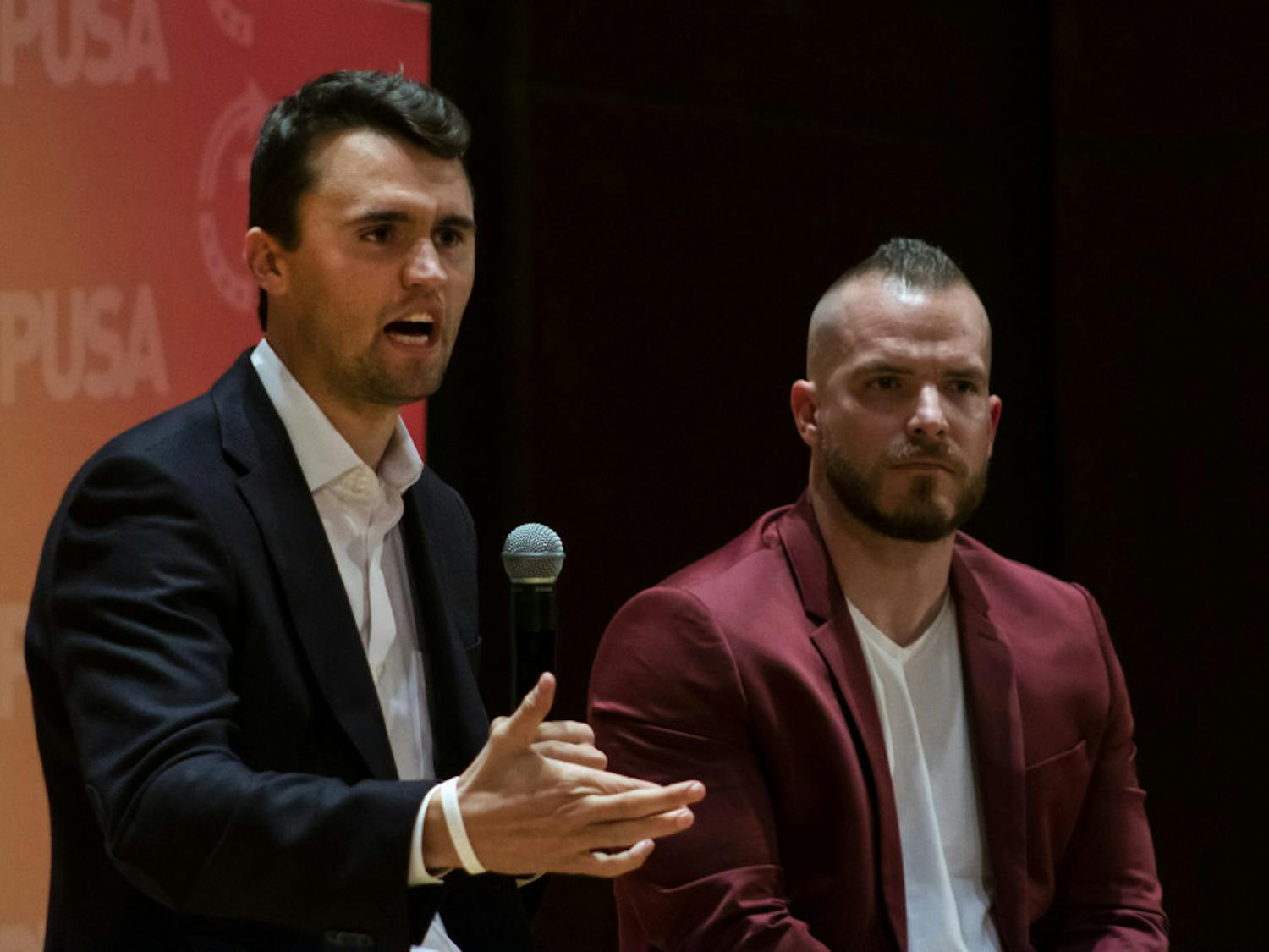 Charlie Kirk, leader of Turning Point USA, and Graham Allen, political speaker, answer questions from the audience Tuesday night in University Auditorium. Many of Kirk’s answers were met with a mixture of cheers and boos from the crowd.