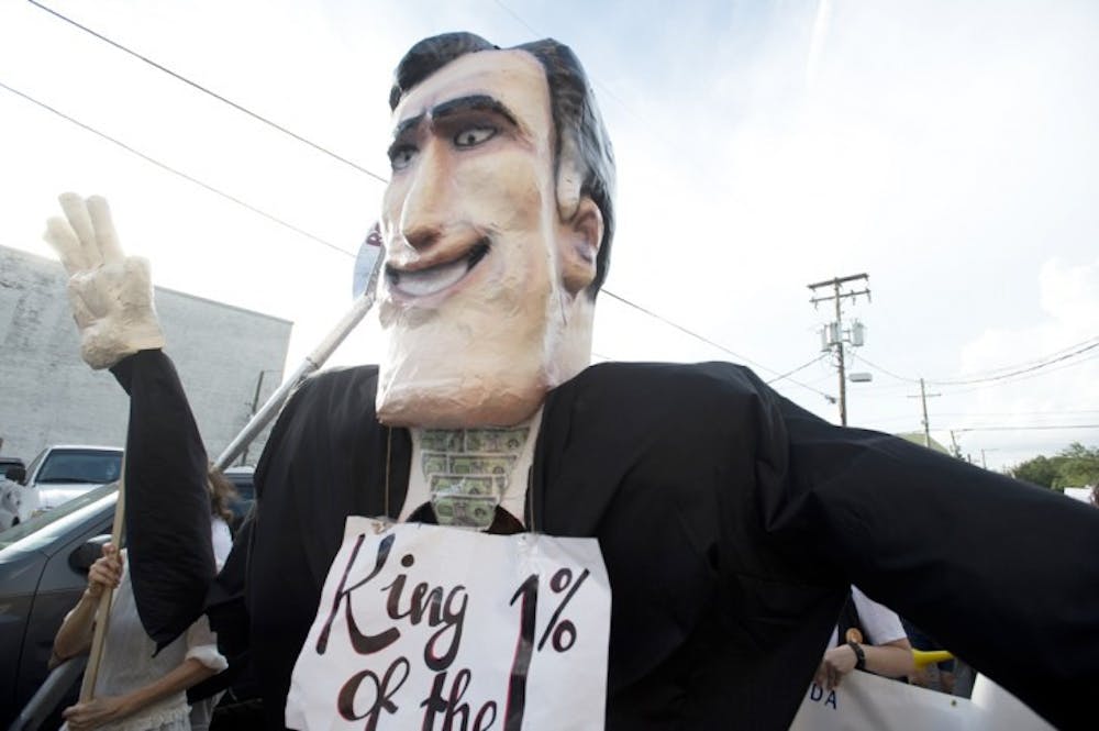 <p>A larger-than-life-size puppet bearing Republican presidential candidate Mitt Romney’s likeness is marched through the streets of Ybor City in Tampa, Fla., on Tuesday.</p>