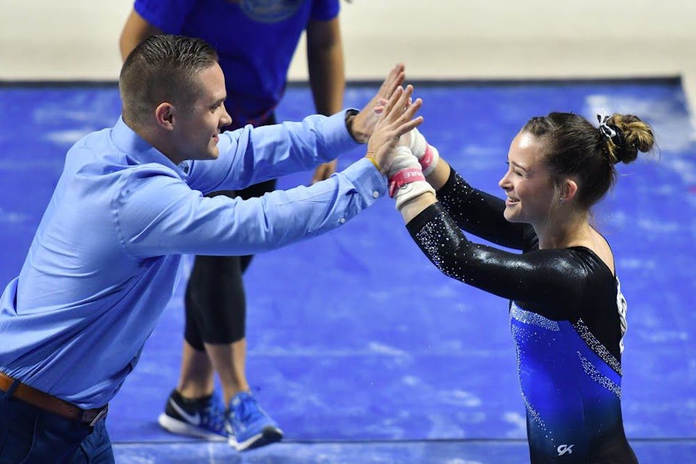 <p>Florida assistant coach Owen Field high fives UF gymnast Maegan Chant during the NCAA Gainesville Regional on Saturday in the O'Connell Center.</p>