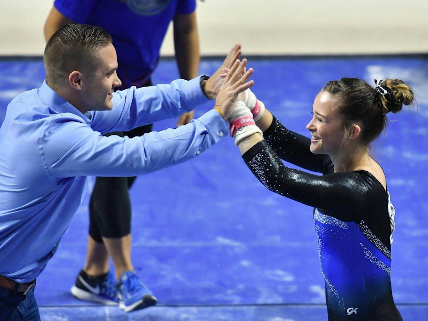 Florida assistant coach Owen Field high fives UF gymnast Maegan Chant during the NCAA Gainesville Regional on Saturday in the O'Connell Center.