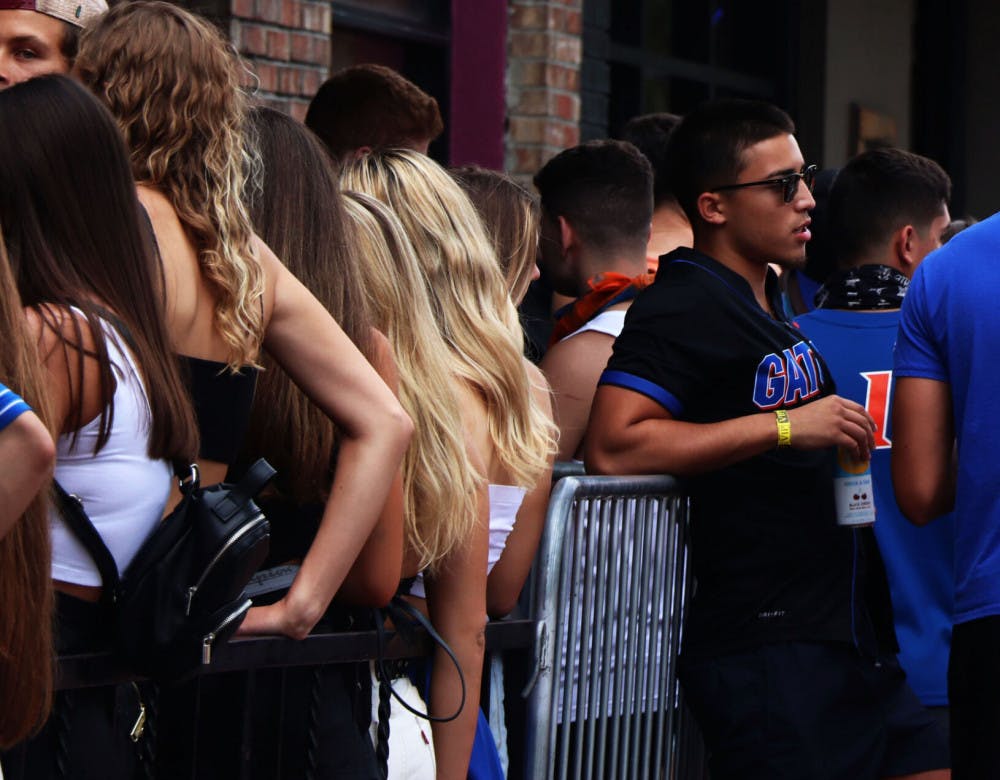 A person is seen standing by the crowded line to enter DownTown Fats, located on S Main St, on Saturday, Oct. 3, 2020, during the first home football game of the season. (Chasity Maynard/Alligator Contributor)