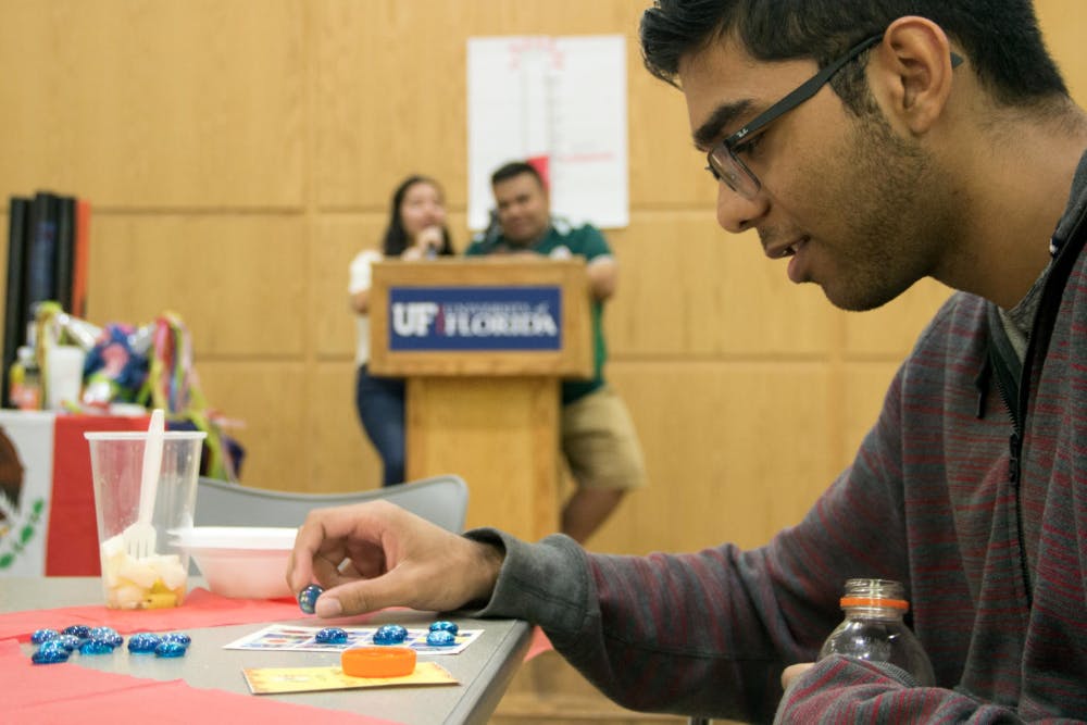 <p><span id="docs-internal-guid-eaae3a9e-7fff-1be3-cb76-32002dfaab1d"><span>Garrick Sewsankar, an 18-year-old computer science freshman, plays Noche de Lotería on Monday, October 15, during a fundraiser held by the Mexican-American Student Association. Similar to Bingo, Sewsankar was one space away from winning the round. Donations from the fundraiser are going to help immigrants receive free legal services.</span></span></p>