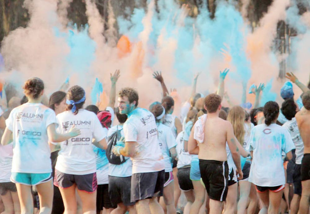 <p dir="ltr">Participants throw powder into the air to celebrate the conclusion of The Gator Run on Saturday.</p>