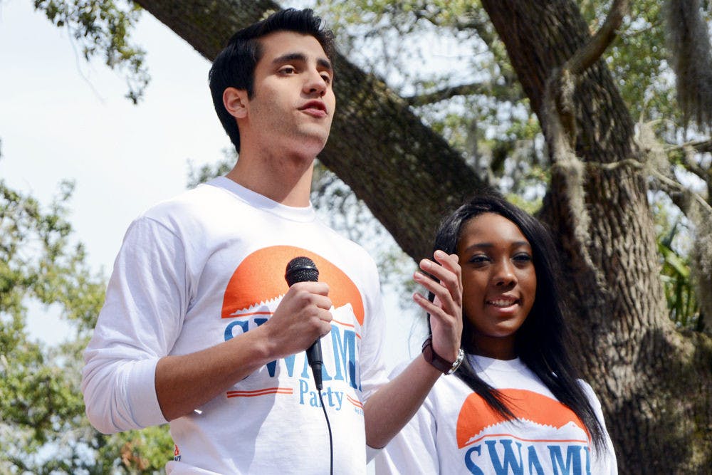 <p>Joseph Michaels (left), Swamp Party’s candidate for student body president, and Tia Smart, Swamp Party’s candidate for student body vice president, release the party’s platform to a crowd of students on Turlington Plaza on Monday morning.</p>