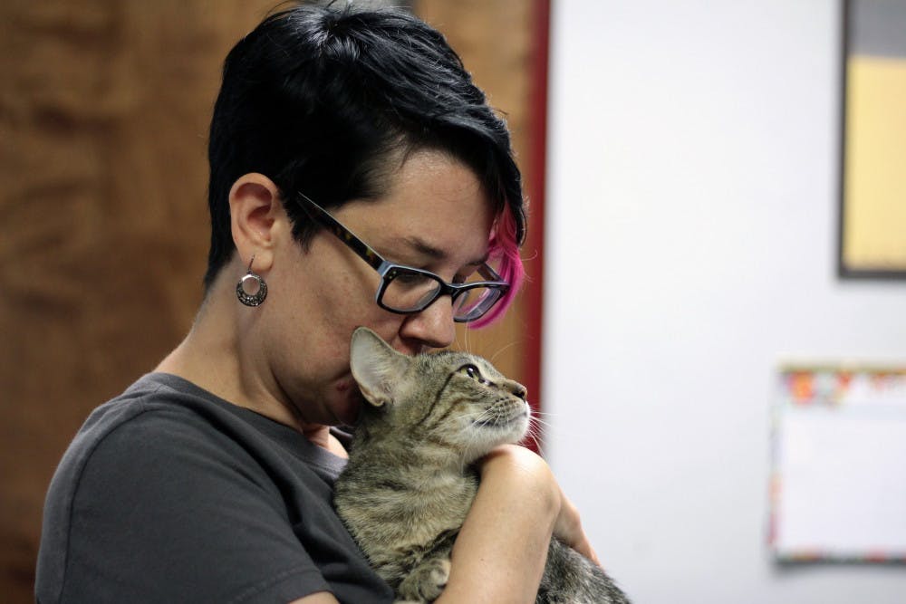 Gainesville resident Amber Young-Parker, 44, holds her new foster cat, Carmilla, at the Alachua County Humane Society. Young-Parker is fostering the cat for two weeks to help the shelter before Hurricane Irma.