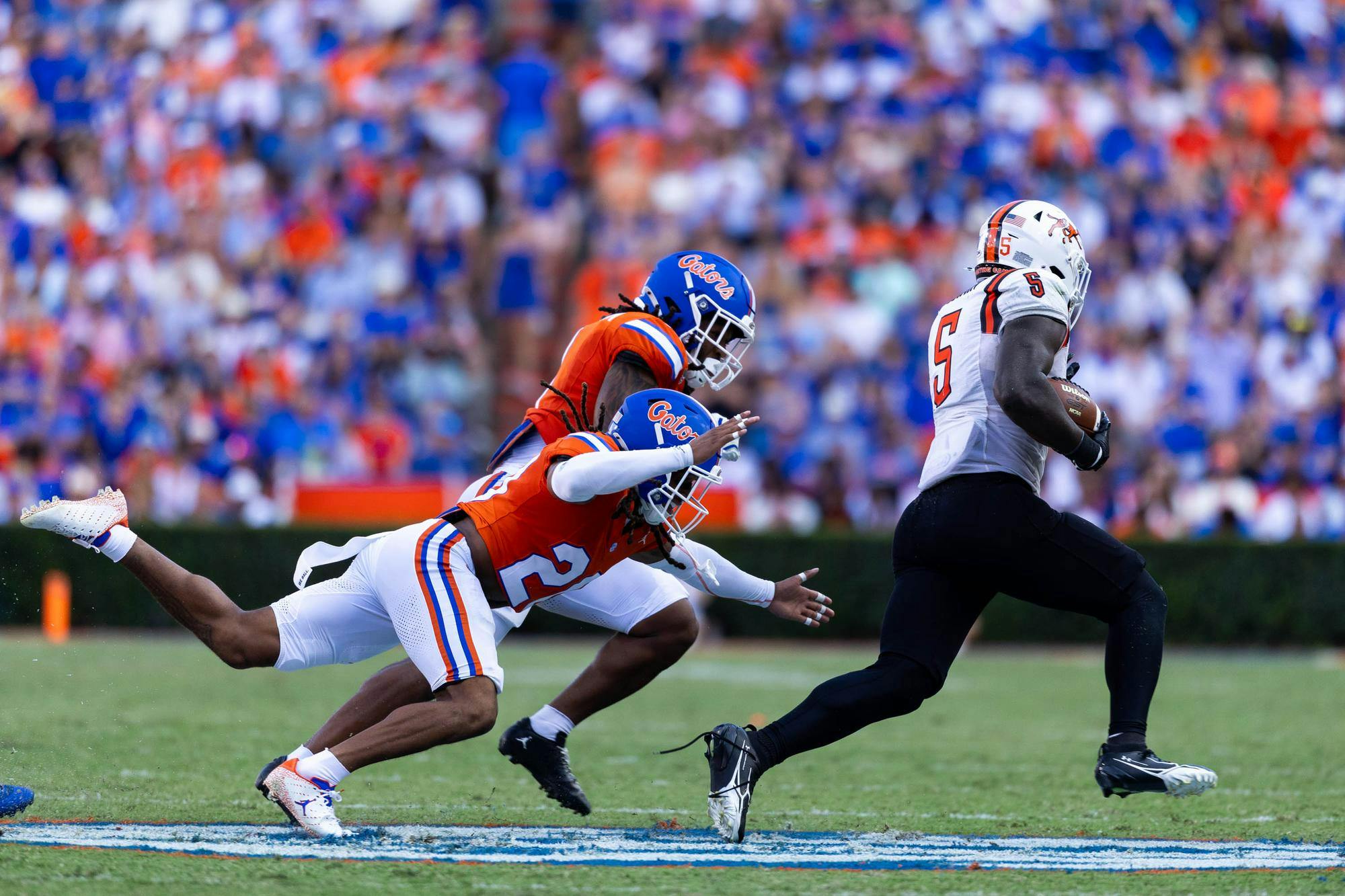 Florida safety Lagonza Hayward (2) reaches for Campbell running back JJ Cowan (5) in the first half of an NCAA college football game against Campbell, Saturday, Sept. 12, 2026, in Gainesville, Fla.