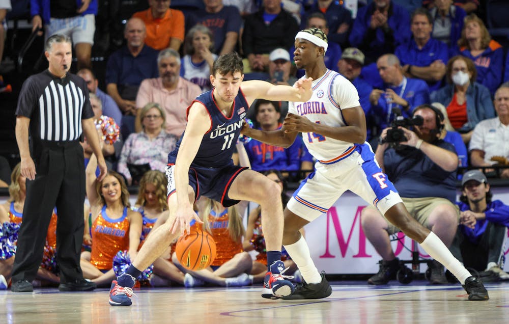Florida guard Kowacie Reeves plays defense against a Connecticut player in the Gators’ 75-54 loss to the Huskies Wednesday, Dec. 7, 2022.