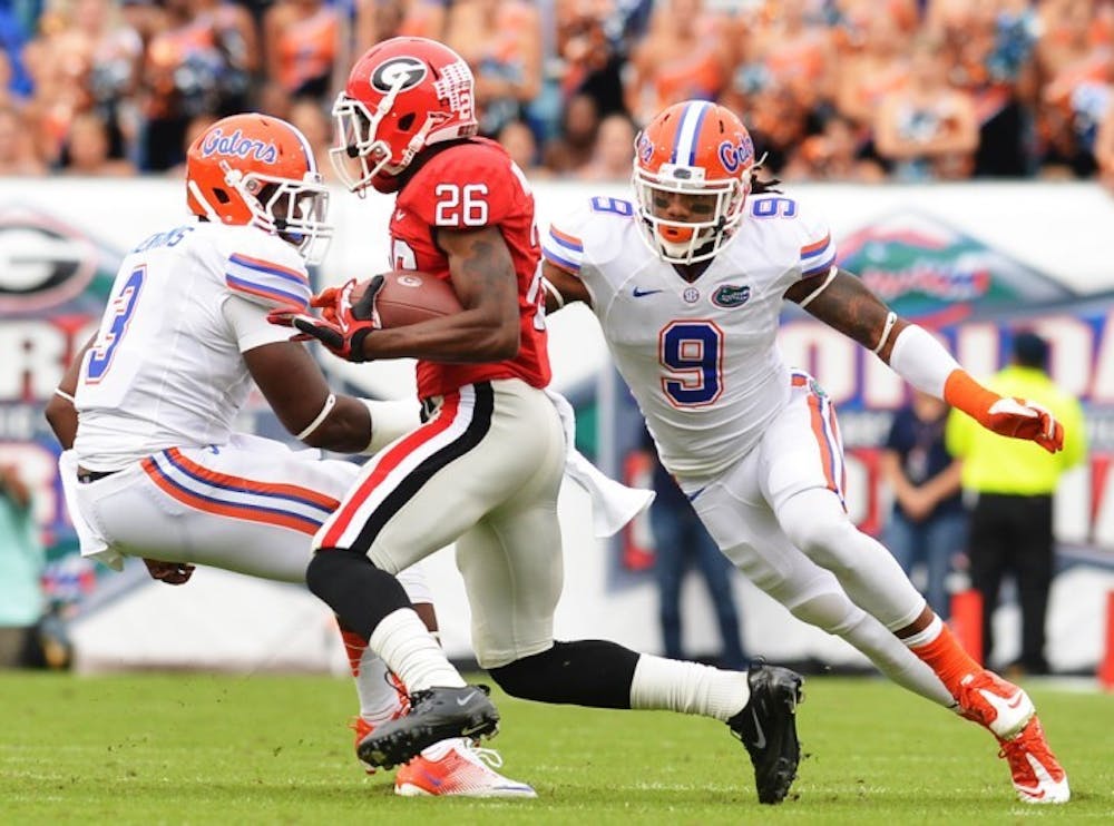 <p>Florida safety Josh Evans chases Georgia wide receiver Malcolm Mitchell at EverBank Field during the Florida-Georgia game in Jacksonville, Fla., on Saturday, October 27, 2012. Georgia won, 17-9.</p>