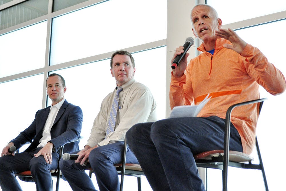 From left: Mike Hill, UAA executive associate athletics director for external affairs, and Chip Howard, executive associate athletics director for internal affairs, watch Jeremy Foley, the UF athletics director, speak about his career at an Accent Speaker’s Bureau event in the Evans Champions Club on Tuesday. “It’s not a perfect science,” he said about the process of hiring a new coach. “The fit part is really important. The honesty and integrity part is really important.”