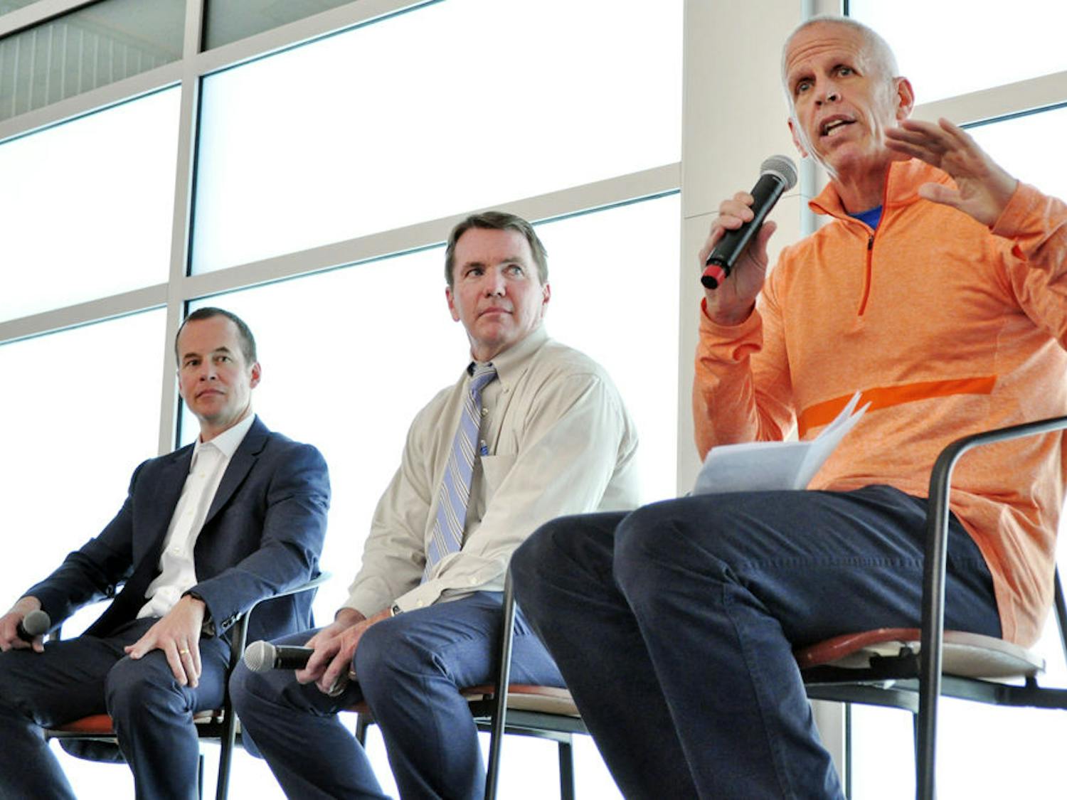 From left: Mike Hill, UAA executive associate athletics director for external affairs, and Chip Howard, executive associate athletics director for internal affairs, watch Jeremy Foley, the UF athletics director, speak about his career at an Accent Speaker’s Bureau event in the Evans Champions Club on Tuesday. “It’s not a perfect science,” he said about the process of hiring a new coach. “The fit part is really important. The honesty and integrity part is really important.”