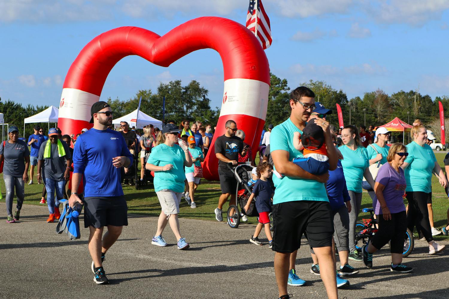 People walk through the American Heart Association inflatable to being the 2022 Alachua County Heart Walk Saturday, Sept. 24, 2022. 