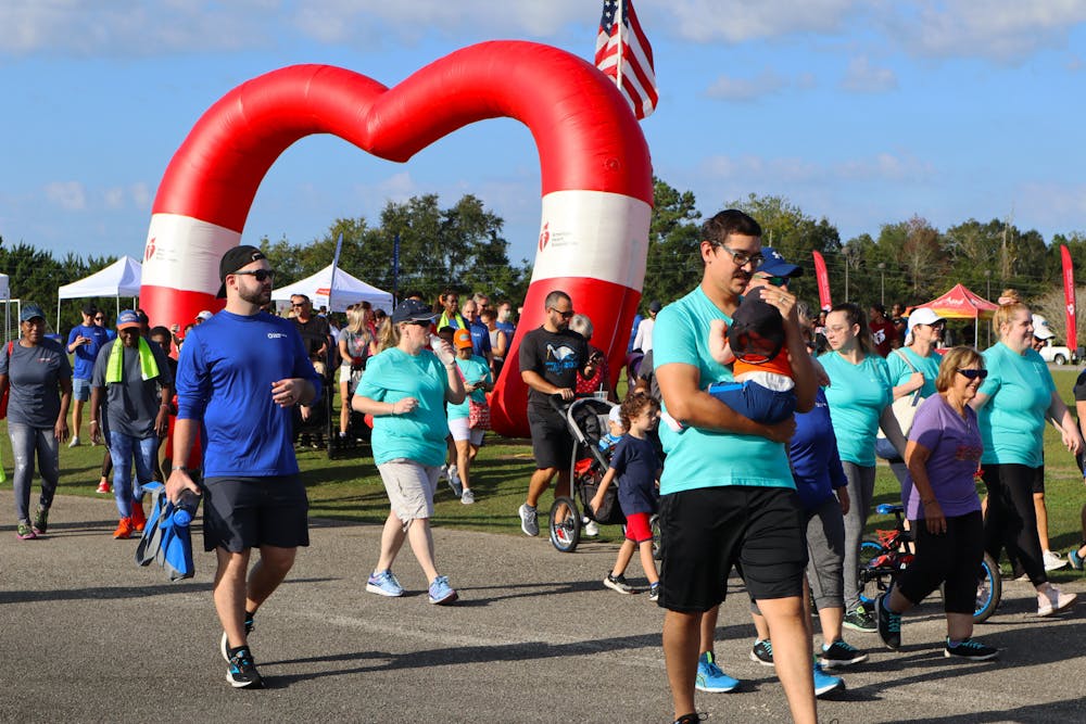 <p>People walk through the American Heart Association inflatable to being the 2022 Alachua County Heart Walk Saturday, Sept. 24, 2022. </p>
