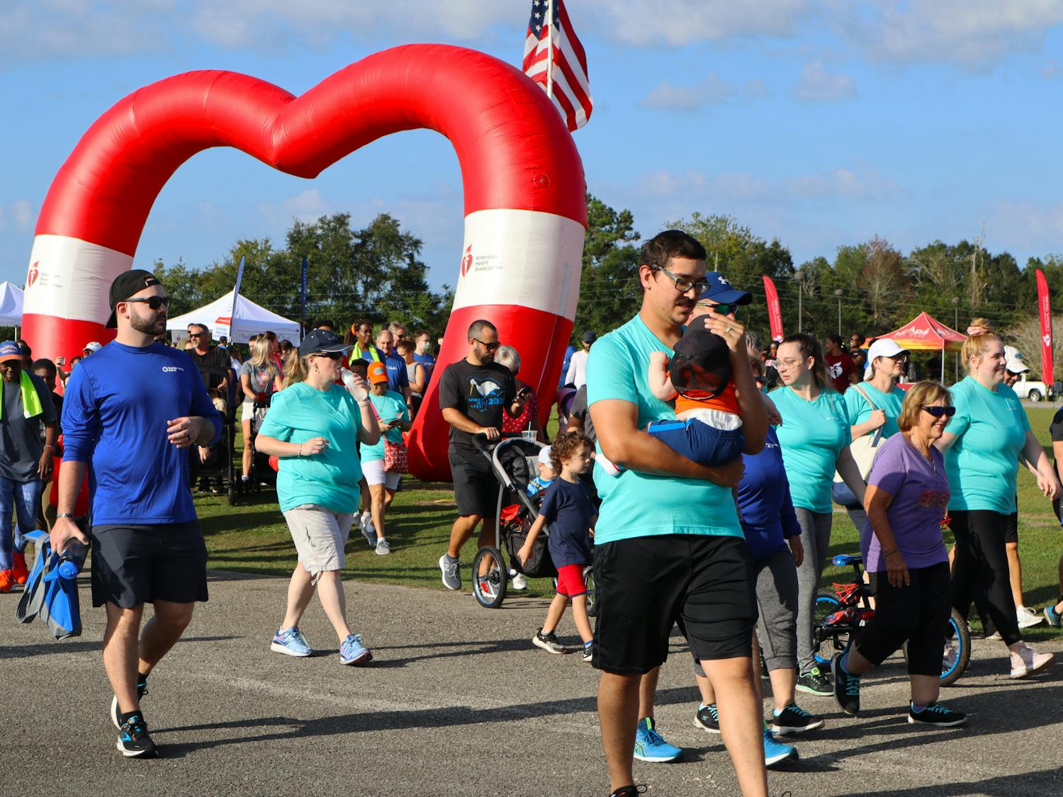 People walk through the American Heart Association inflatable to being the 2022 Alachua County Heart Walk Saturday, Sept. 24, 2022.
