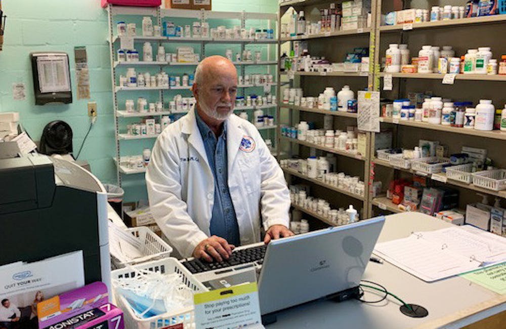 Tim Rogers looks at a computer inside the Grace Pharmacy (Photo courtesy of Lorry Davis, programs administrator for Grace Healthcare Services)
