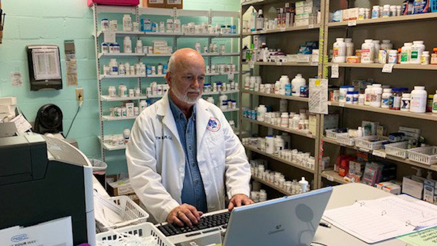 Tim Rogers looks at a computer inside the Grace Pharmacy (Photo courtesy of Lorry Davis, programs administrator for Grace Healthcare Services)
