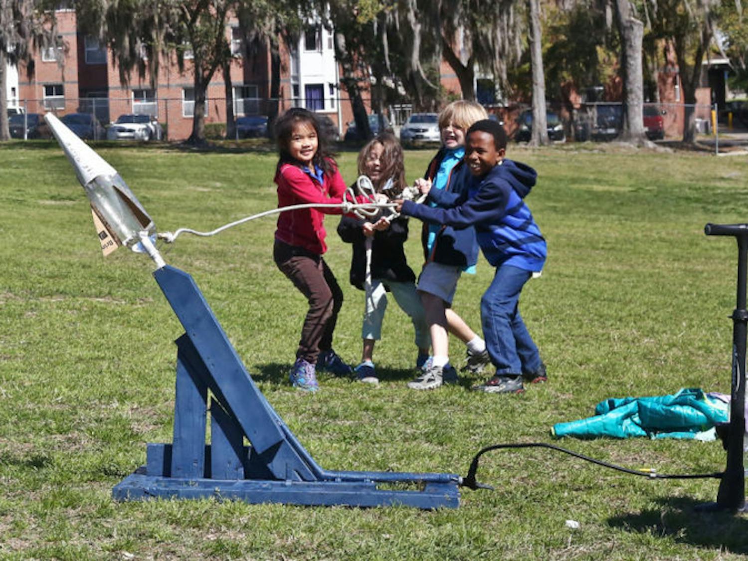 Second and third graders from Idylwild Elementary School launch bottle rockets on Flavet Field on Thursday morning. The American Institute of Aeronautics and Astronautics at UF assisted the students in building the rockets and launching them for the field trip.